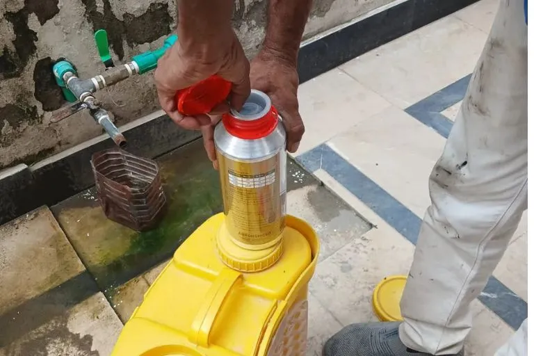 Termite treatment chemical mixing process on-site in Lahore